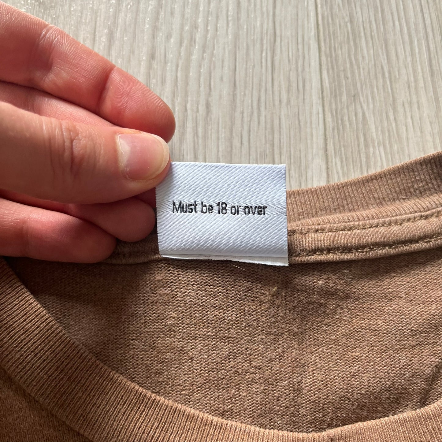 Vintage 90’s Porn Star Clothing longsleeve in brown, featuring a bold pink logo on the chest with a silhouette outline of a woman between the words “Porn” and “Star.” Crafted with quality construction, it carries the brand’s signature edgy aesthetic. Finished with a playful “must be 18 or over” detail on the tag, this rare piece embodies 90’s streetwear provocative style.