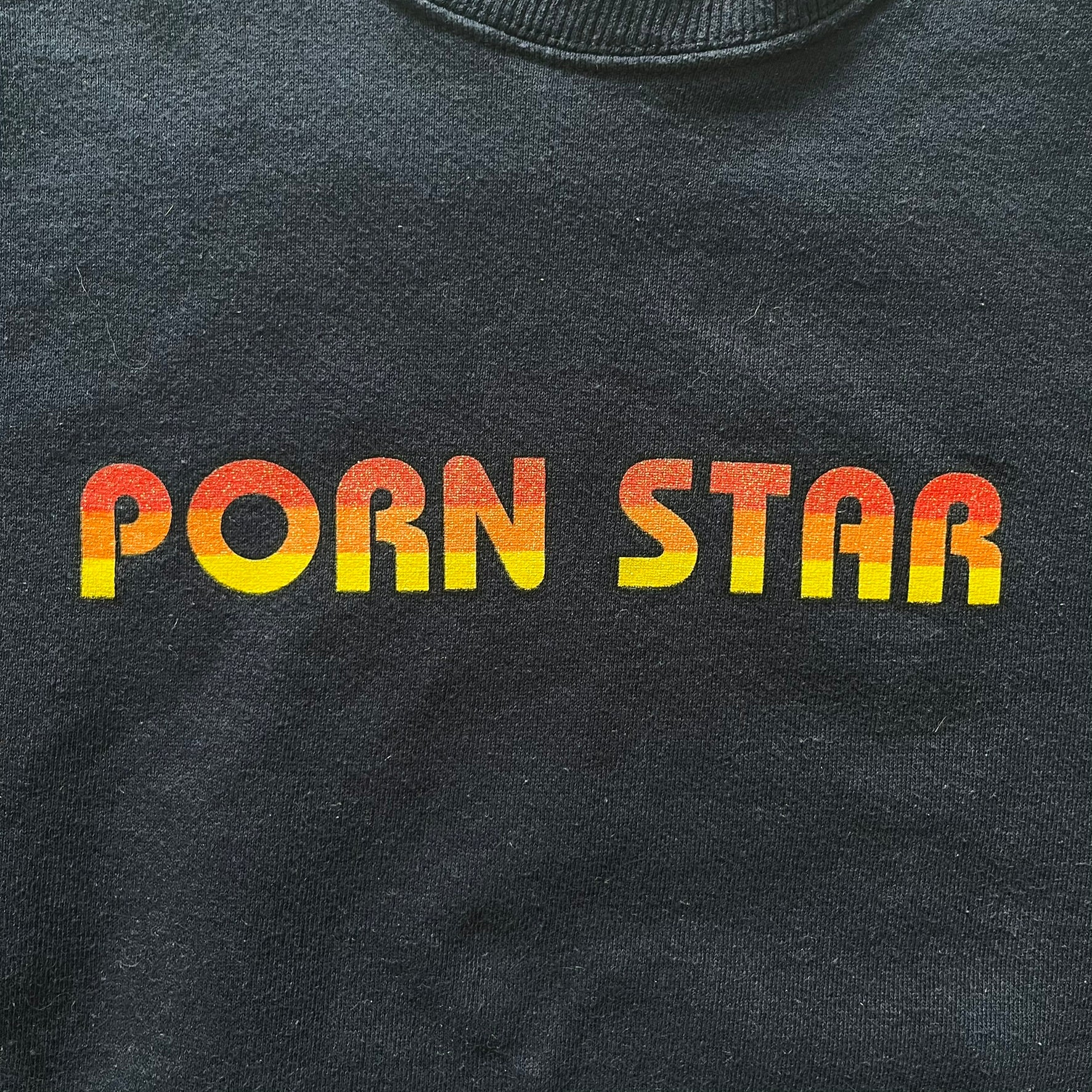 Black t-shirt with 'Porn Star' text in gradient colors on a plain background