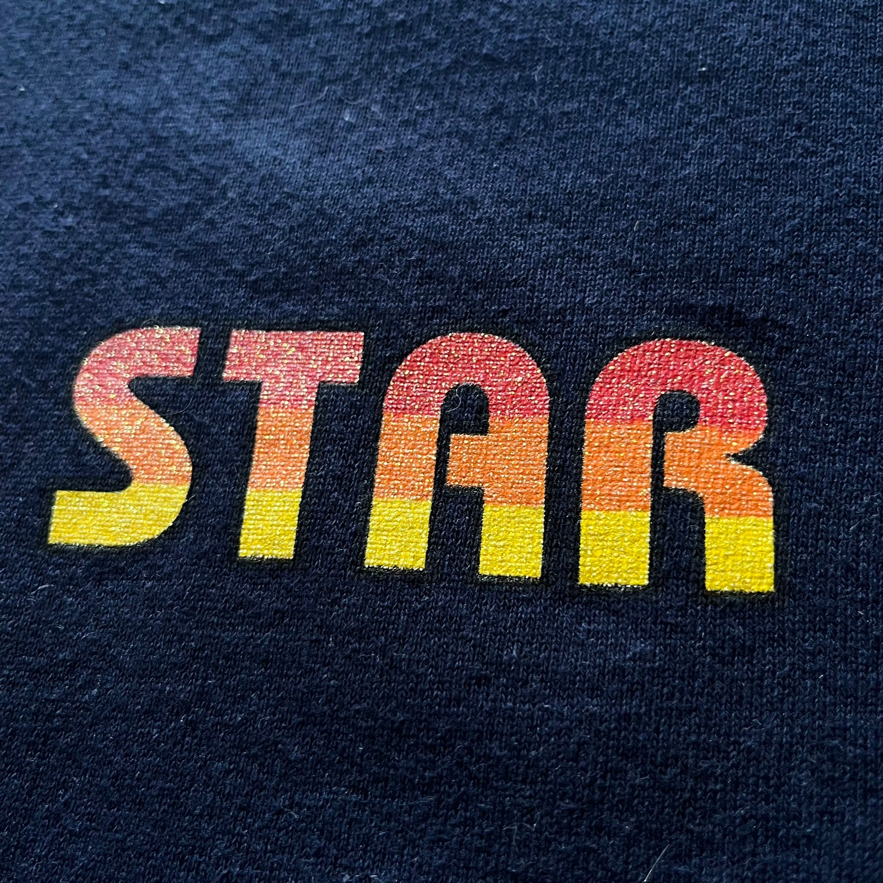Colorful 'STAR' text on a dark blue fabric background