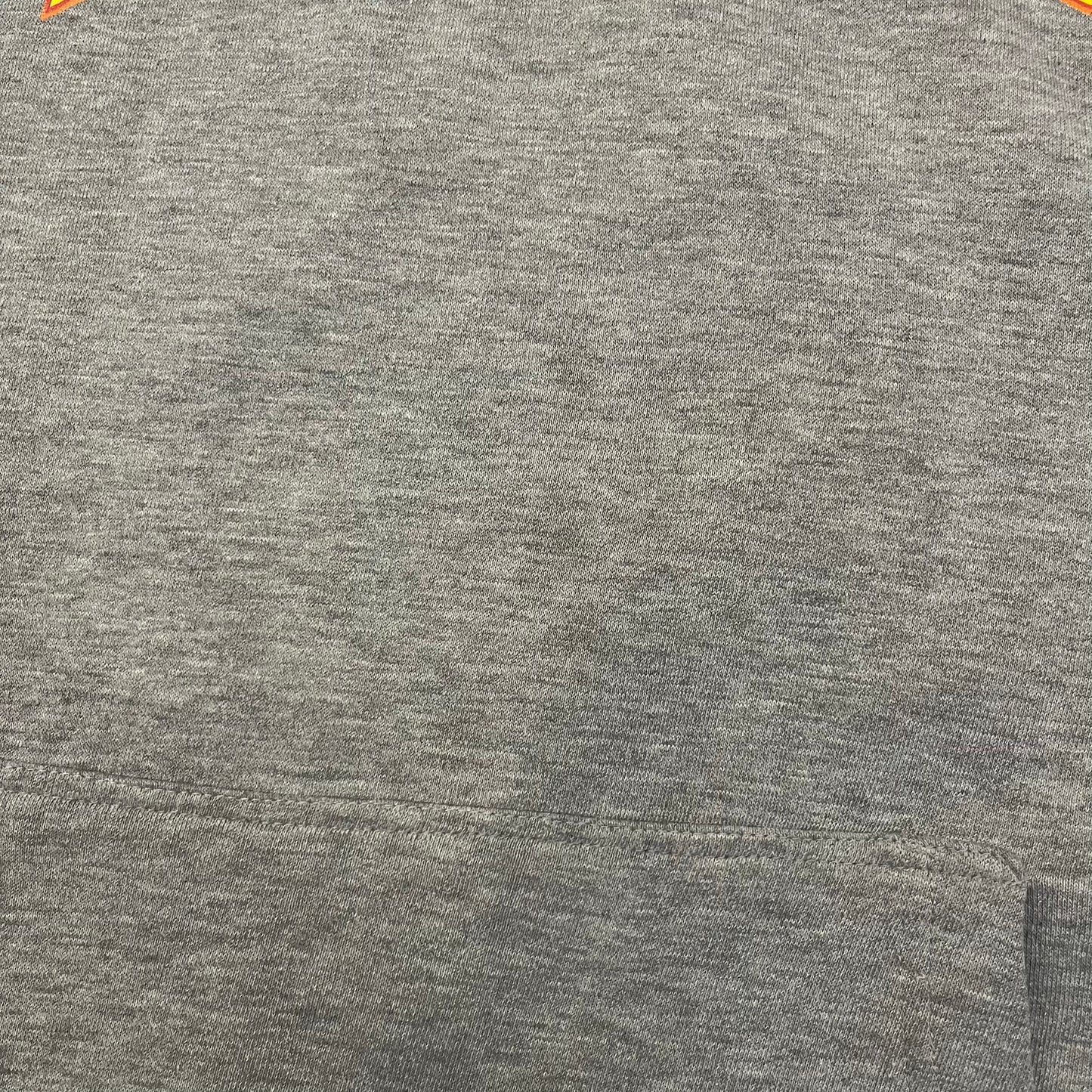 Porn Star Clothing Thrasher Hoodie from the 1990s, made in a gray cotton fabric. The front features a large flame-style “Pornstar” logo that is a spin-off of the Trasher one, with matching flame graphics running down both sleeves. Designed with an adjustable drawstring hood, front kangaroo pocket, and ribbed cuffs and hem. Finished with the original “Must Be 18 Or Over” Porn Star Clothing tag.