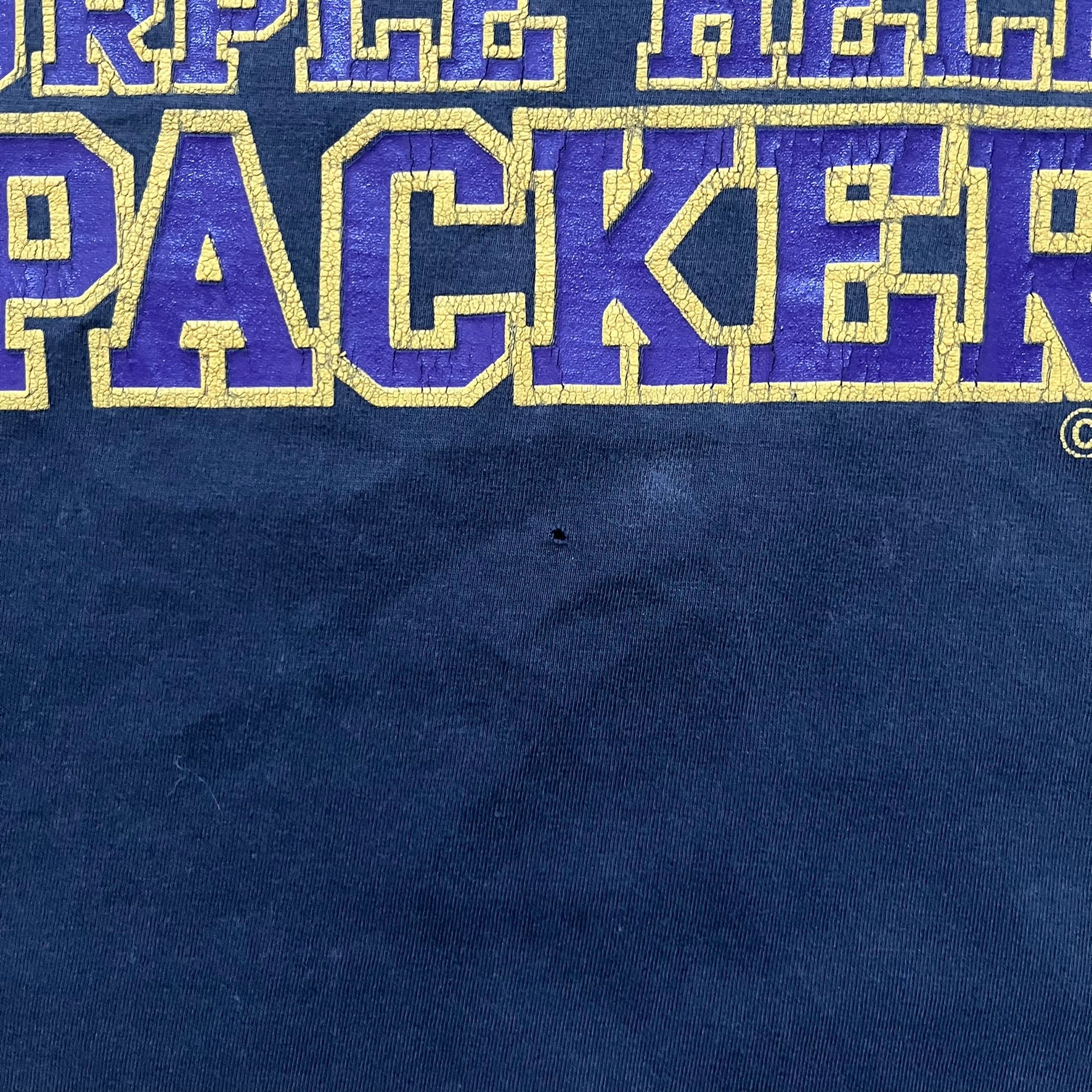 Black T-shirt with a purple football helmet graphic featuring a “P” letter. “Porn Star” text above the helmet in purple with a yellow outline, and “Helmet Packers” text below in purple with a yellow outline. Includes a small Porn Star copyright logo. Vintage piece.