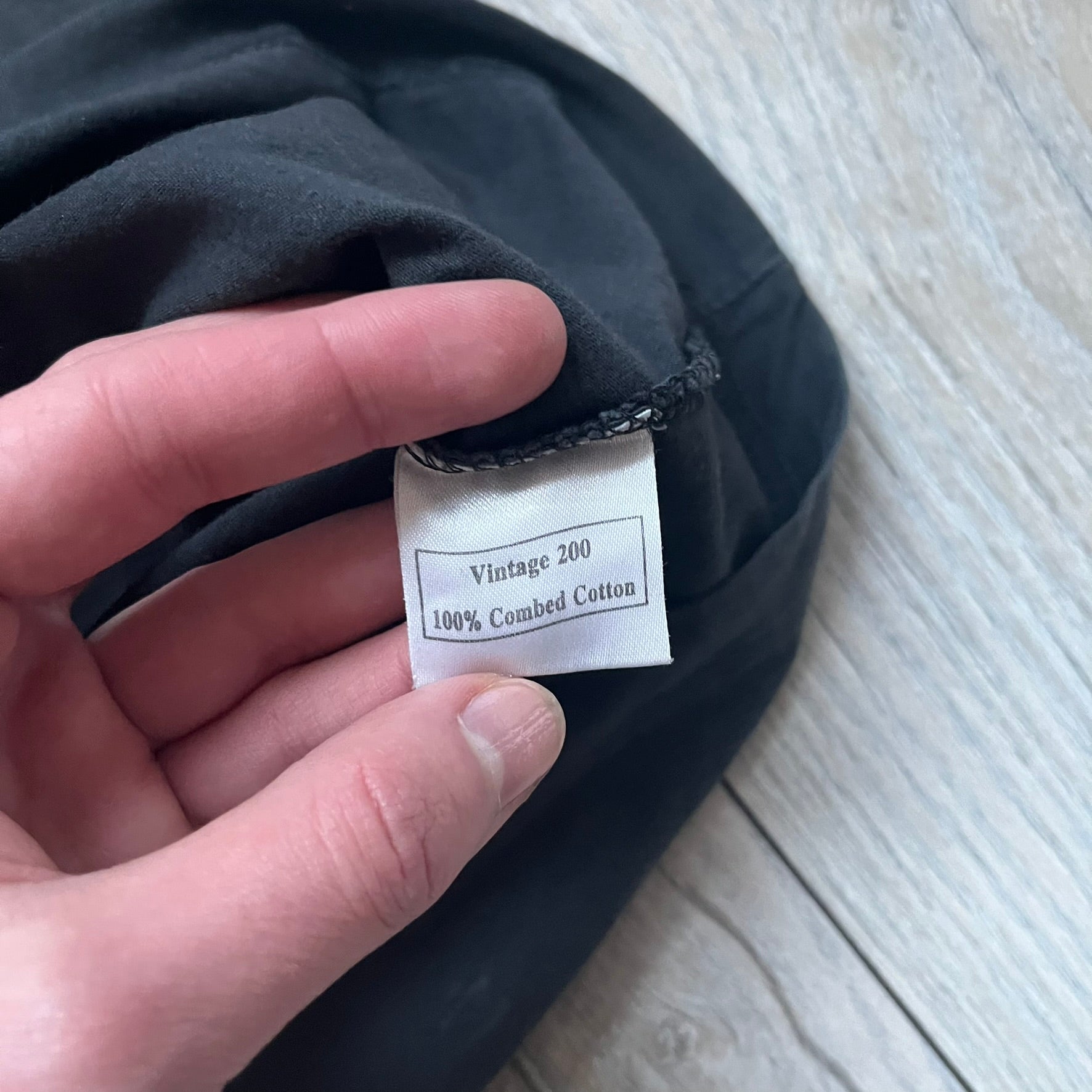 Black T-shirt with a purple football helmet graphic featuring a “P” letter. “Porn Star” text above the helmet in purple with a yellow outline, and “Helmet Packers” text below in purple with a yellow outline. Includes a small Porn Star copyright logo. Vintage piece.