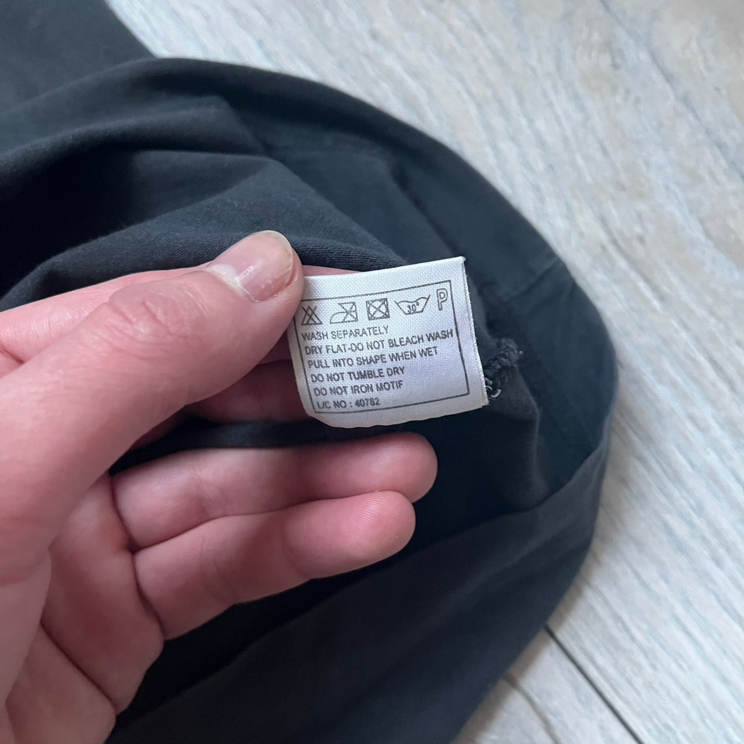 Black T-shirt with a purple football helmet graphic featuring a “P” letter. “Porn Star” text above the helmet in purple with a yellow outline, and “Helmet Packers” text below in purple with a yellow outline. Includes a small Porn Star copyright logo. Vintage piece.