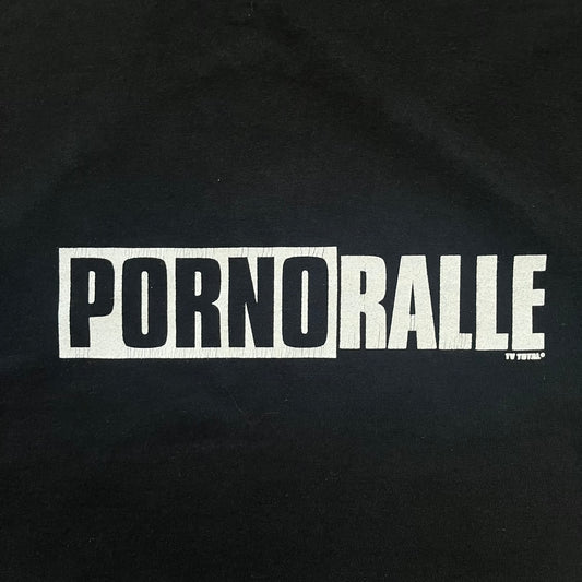 PornoRalle TV 1990s Black Tee is a black short-sleeve T-shirt made on a Jerzees blank. The front features a white PornoRalle logo on the chest with small “TV Total” text beneath. This minimalist design dates from the 1990s.