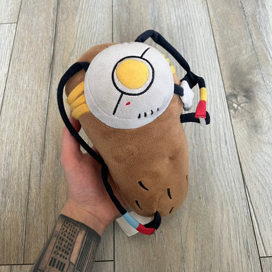 Portal 2 GLaDOS PotatOS 2013 ThinkGeek Talking Plush is a collectible plush toy based on the PotatOS version of GLaDOS from the Portal 2 video game. The plush features a soft construction with integrated electronics, including 10 pre-recorded voice lines activated by a button, along with a light-up eye effect. It requires 3 AA batteries (not included), includes an on/off switch hidden in the back compartment, and was produced by ThinkGeek in 2013.