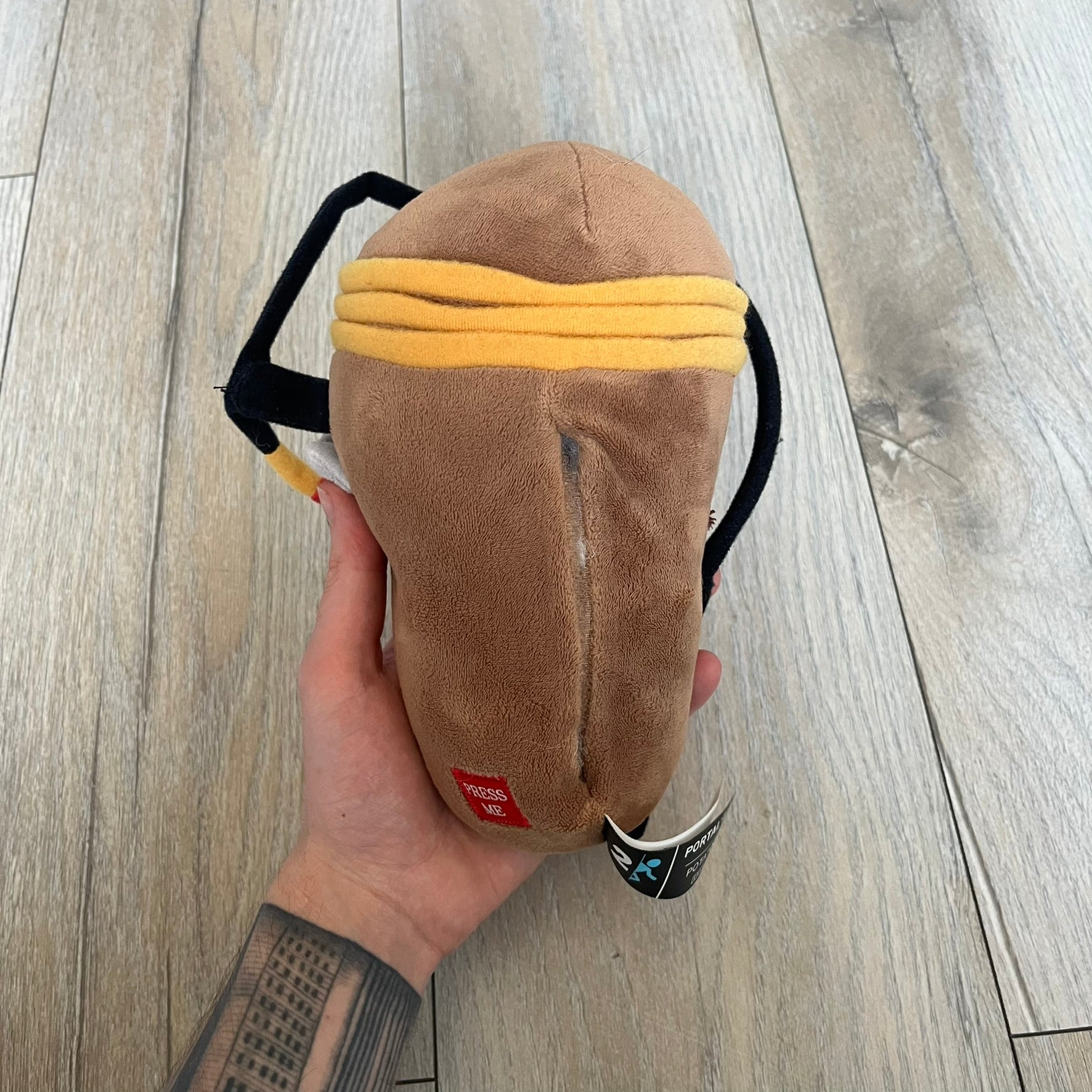 Portal 2 GLaDOS PotatOS 2013 ThinkGeek Talking Plush is a collectible plush toy based on the PotatOS version of GLaDOS from the Portal 2 video game. The plush features a soft construction with integrated electronics, including 10 pre-recorded voice lines activated by a button, along with a light-up eye effect. It requires 3 AA batteries (not included), includes an on/off switch hidden in the back compartment, and was produced by ThinkGeek in 2013.