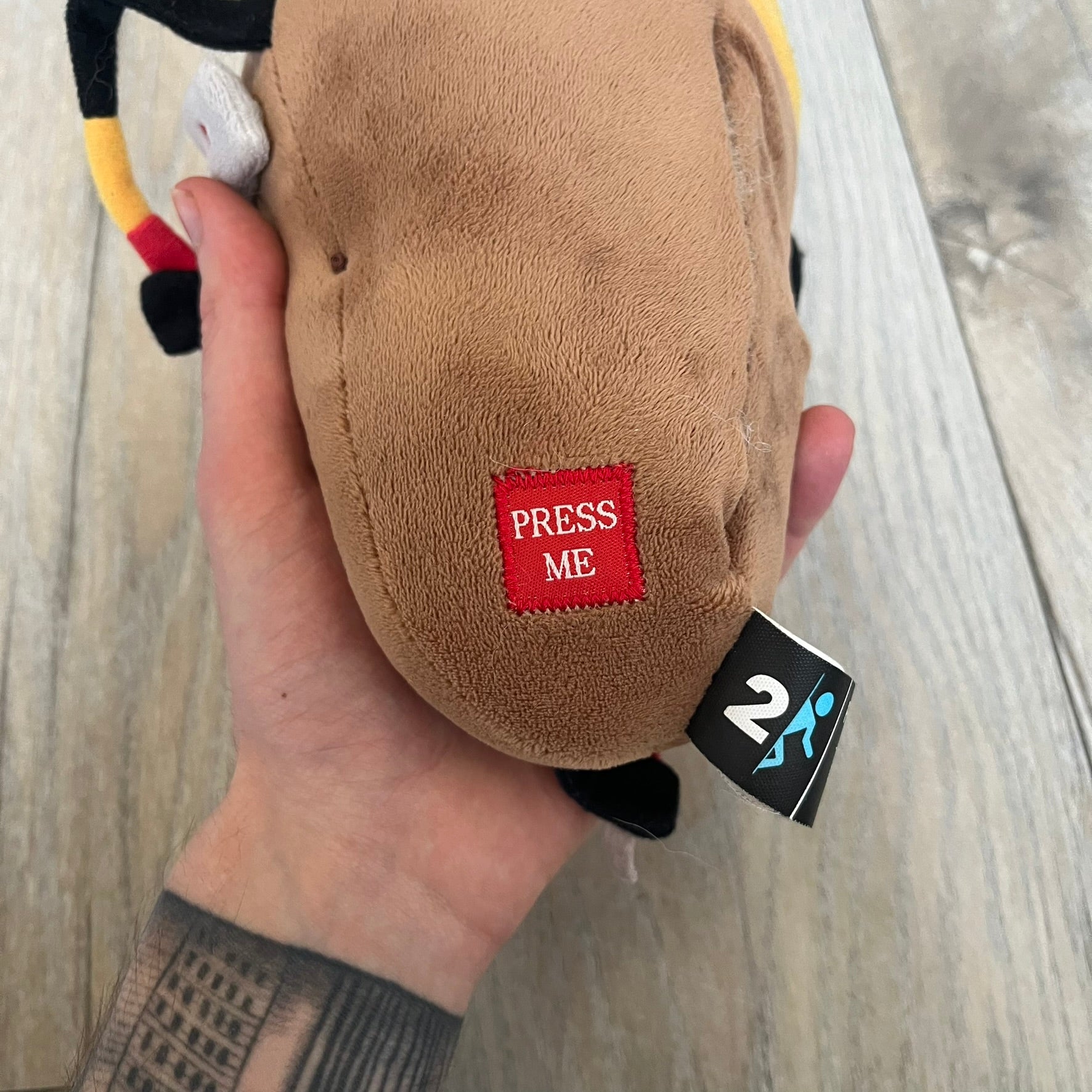 Portal 2 GLaDOS PotatOS 2013 ThinkGeek Talking Plush is a collectible plush toy based on the PotatOS version of GLaDOS from the Portal 2 video game. The plush features a soft construction with integrated electronics, including 10 pre-recorded voice lines activated by a button, along with a light-up eye effect. It requires 3 AA batteries (not included), includes an on/off switch hidden in the back compartment, and was produced by ThinkGeek in 2013.