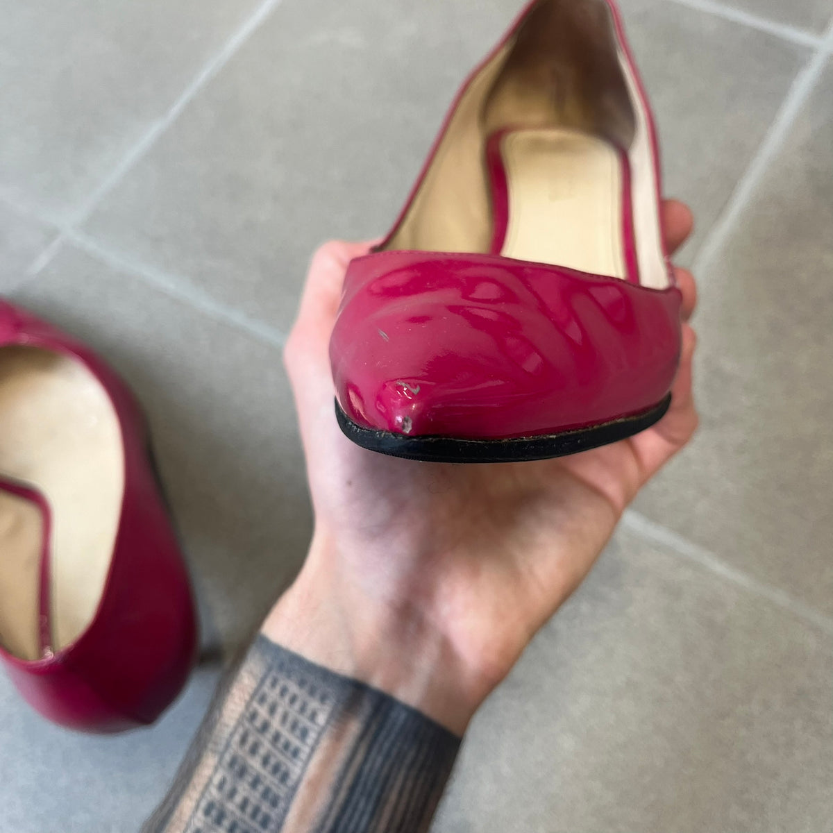 Prada 2000's Patent Leather Magenta Kitten Heels are made in Italy from magenta patent leather with a beige interior and sole, featuring a gold-tone metal Prada logo on the bottom and Prada branding on the insole. They come with the original box and two dust bags; the bottom and heel tip have been professionally repaired.