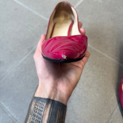 Prada 2000's Patent Leather Magenta Kitten Heels are made in Italy from magenta patent leather with a beige interior and sole, featuring a gold-tone metal Prada logo on the bottom and Prada branding on the insole. They come with the original box and two dust bags; the bottom and heel tip have been professionally repaired.