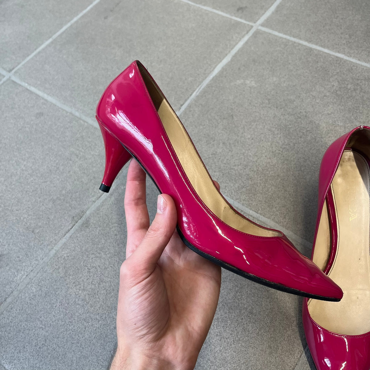 Prada 2000's Patent Leather Magenta Kitten Heels are made in Italy from magenta patent leather with a beige interior and sole, featuring a gold-tone metal Prada logo on the bottom and Prada branding on the insole. They come with the original box and two dust bags; the bottom and heel tip have been professionally repaired.