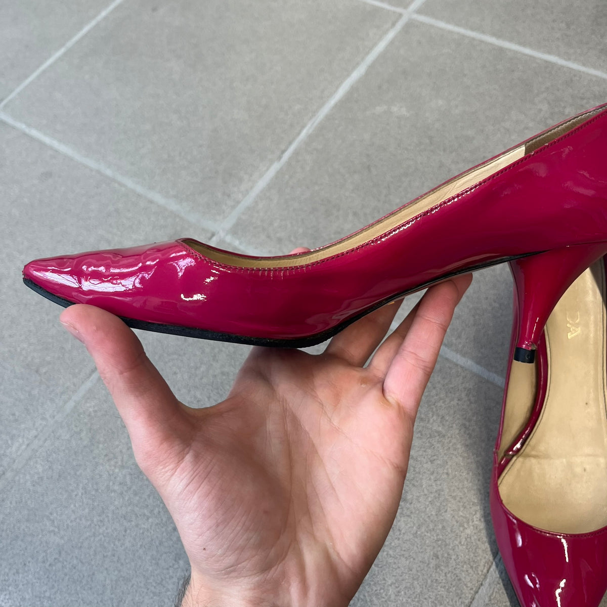 Prada 2000's Patent Leather Magenta Kitten Heels are made in Italy from magenta patent leather with a beige interior and sole, featuring a gold-tone metal Prada logo on the bottom and Prada branding on the insole. They come with the original box and two dust bags; the bottom and heel tip have been professionally repaired.