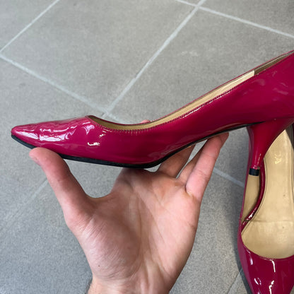 Prada 2000's Patent Leather Magenta Kitten Heels are made in Italy from magenta patent leather with a beige interior and sole, featuring a gold-tone metal Prada logo on the bottom and Prada branding on the insole. They come with the original box and two dust bags; the bottom and heel tip have been professionally repaired.