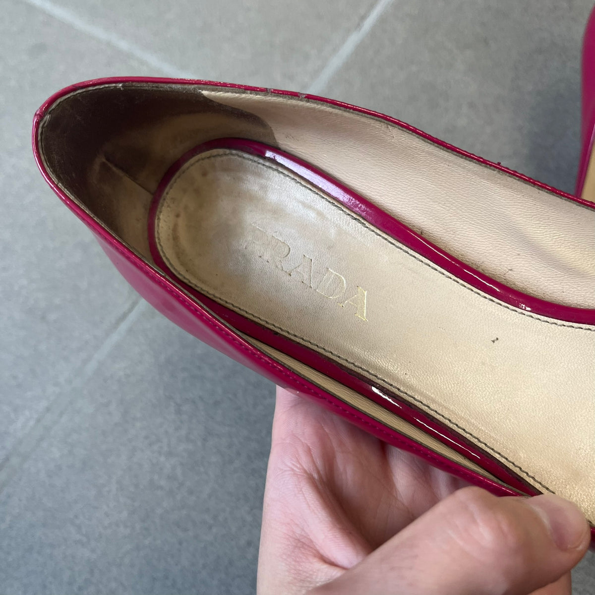 Prada 2000's Patent Leather Magenta Kitten Heels are made in Italy from magenta patent leather with a beige interior and sole, featuring a gold-tone metal Prada logo on the bottom and Prada branding on the insole. They come with the original box and two dust bags; the bottom and heel tip have been professionally repaired.