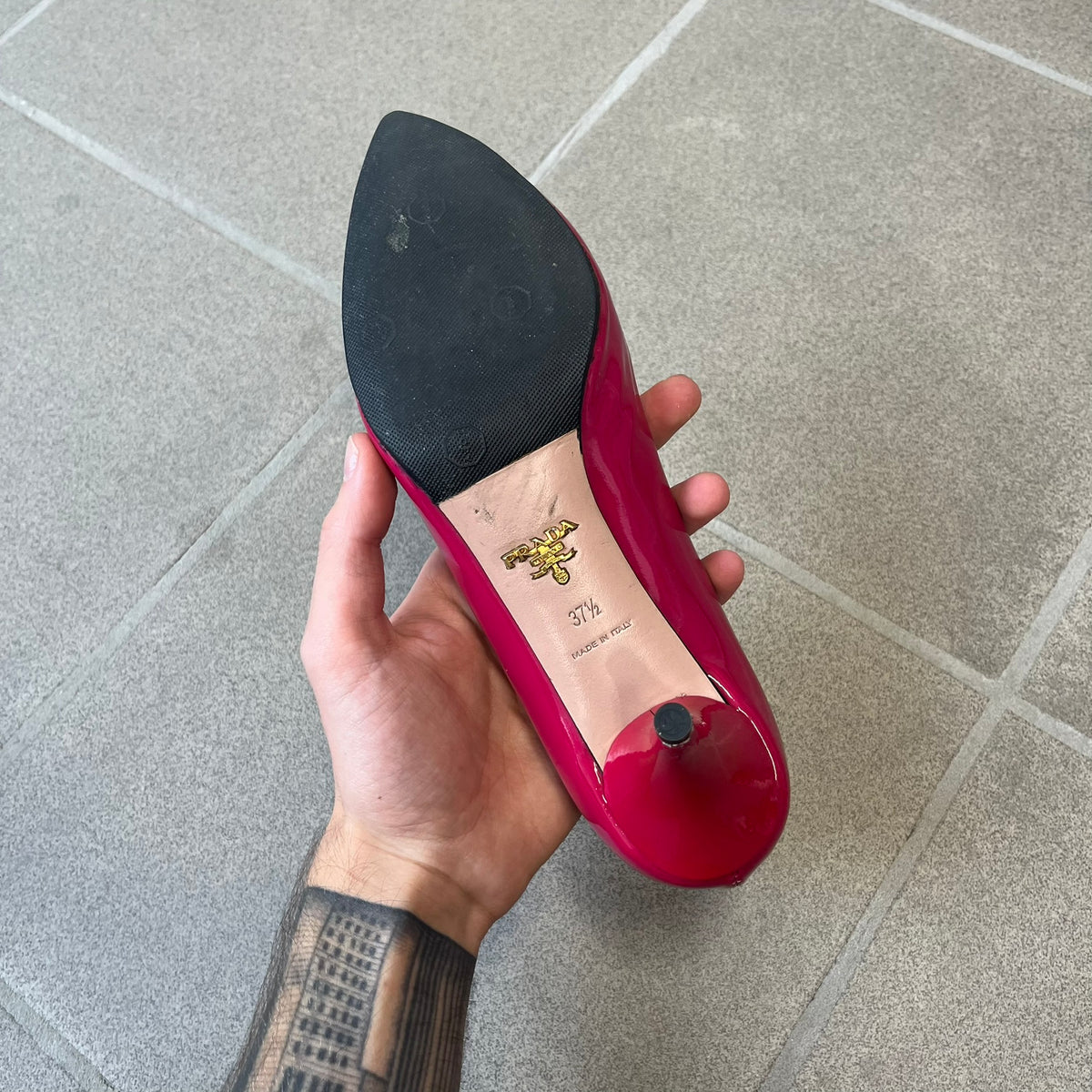 Prada 2000's Patent Leather Magenta Kitten Heels are made in Italy from magenta patent leather with a beige interior and sole, featuring a gold-tone metal Prada logo on the bottom and Prada branding on the insole. They come with the original box and two dust bags; the bottom and heel tip have been professionally repaired.