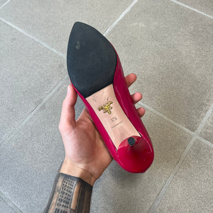 Prada 2000's Patent Leather Magenta Kitten Heels are made in Italy from magenta patent leather with a beige interior and sole, featuring a gold-tone metal Prada logo on the bottom and Prada branding on the insole. They come with the original box and two dust bags; the bottom and heel tip have been professionally repaired.