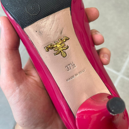 Prada 2000's Patent Leather Magenta Kitten Heels are made in Italy from magenta patent leather with a beige interior and sole, featuring a gold-tone metal Prada logo on the bottom and Prada branding on the insole. They come with the original box and two dust bags; the bottom and heel tip have been professionally repaired.
