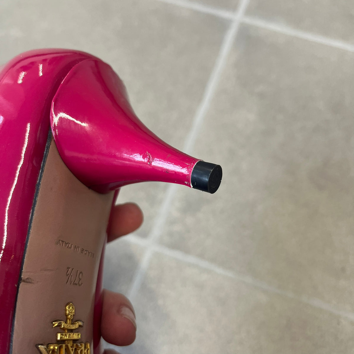 Prada 2000's Patent Leather Magenta Kitten Heels are made in Italy from magenta patent leather with a beige interior and sole, featuring a gold-tone metal Prada logo on the bottom and Prada branding on the insole. They come with the original box and two dust bags; the bottom and heel tip have been professionally repaired.