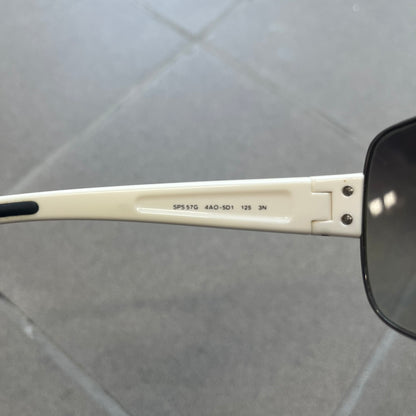 Prada Linea Rossa SPS57G White Sunglasses are shield-style sunglasses featuring a single dark wraparound lens and white arms. One temple is finished with the signature red Prada Linea Rossa logo insert, while the nose pads feature subtle Prada branding. Made in Italy, the sunglasses are lightweight sporty design&nbsp;and they come complete with the original Prada case.