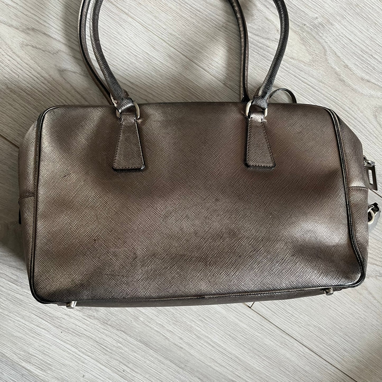 Vintage Prada Metallic Saffiano Bauletto Bag crafted from metallic gold saffiano leather embodies vintage elegance and modern luxury. Detailed with gold-tone hardware, dual handles, and original accessories, it’s a testament to Prada’s enduring craftsmanship. A collector’s piece made to shine on any occasion.