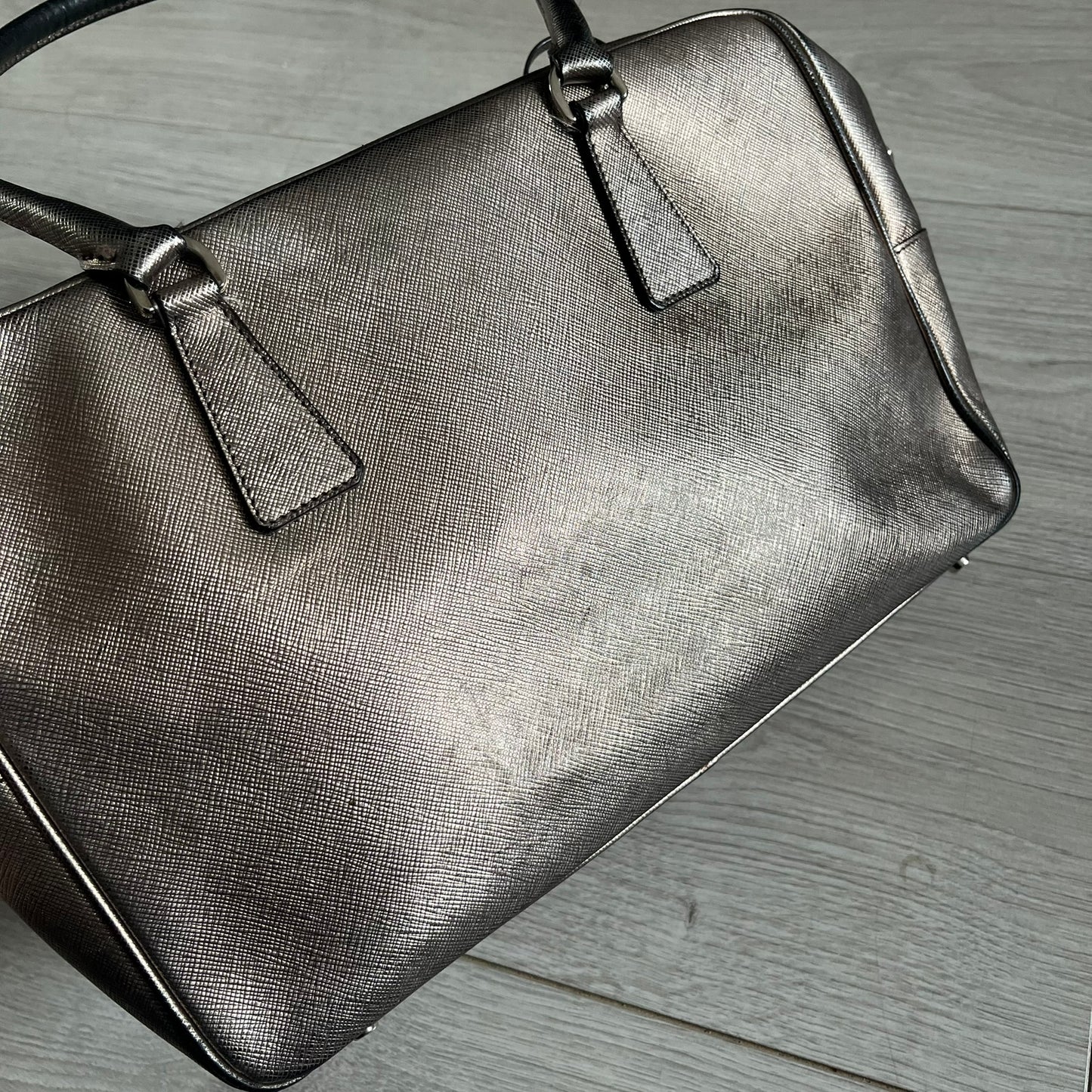 Vintage Prada Metallic Saffiano Bauletto Bag crafted from metallic gold saffiano leather embodies vintage elegance and modern luxury. Detailed with gold-tone hardware, dual handles, and original accessories, it’s a testament to Prada’s enduring craftsmanship. A collector’s piece made to shine on any occasion.