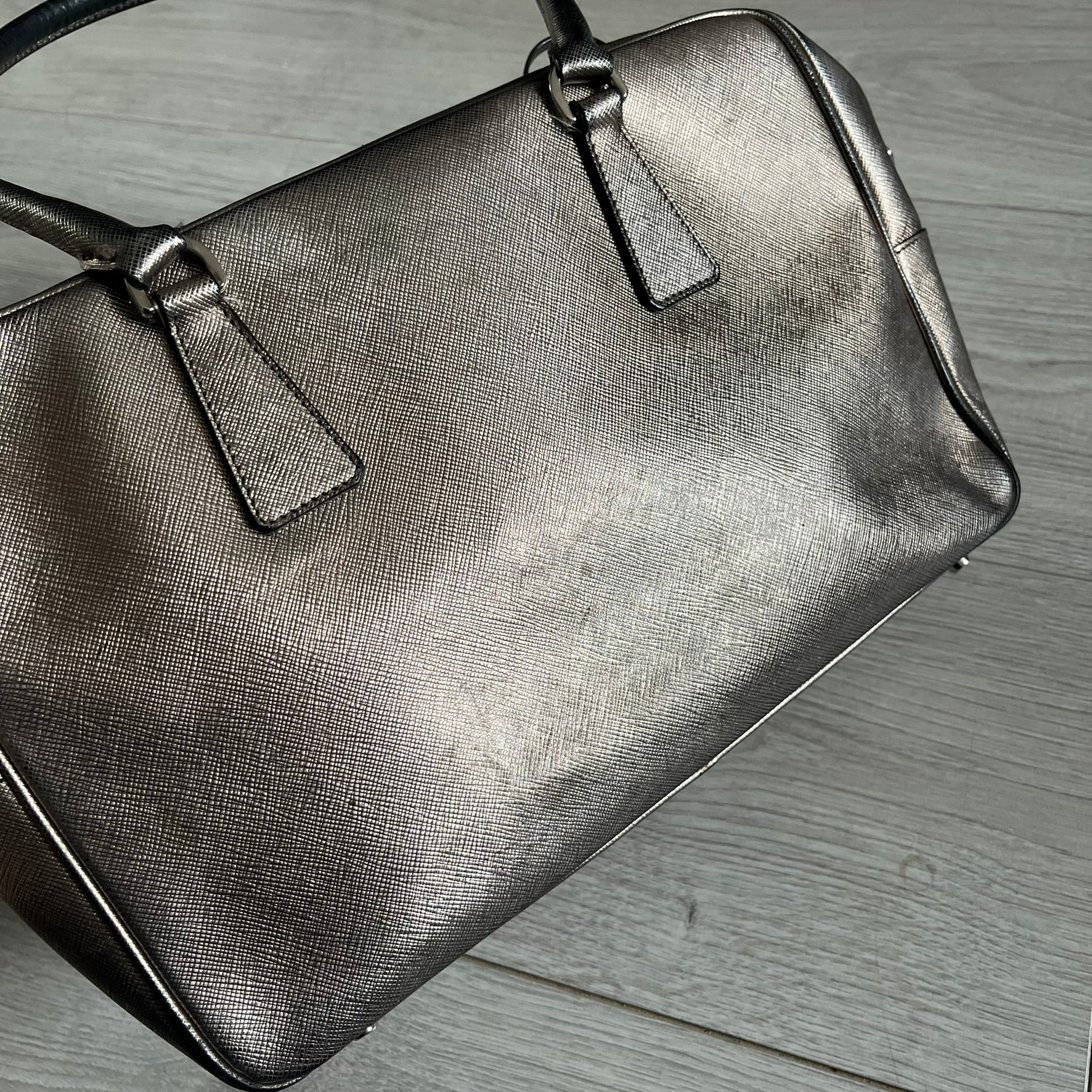 Vintage Prada Metallic Saffiano Bauletto Bag crafted from metallic gold saffiano leather embodies vintage elegance and modern luxury. Detailed with gold-tone hardware, dual handles, and original accessories, it’s a testament to Prada’s enduring craftsmanship. A collector’s piece made to shine on any occasion.