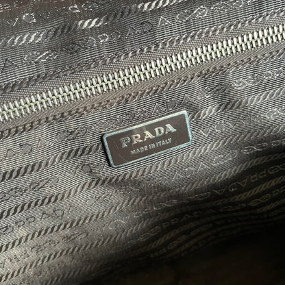 Vintage Prada Metallic Saffiano Bauletto Bag crafted from metallic gold saffiano leather embodies vintage elegance and modern luxury. Detailed with gold-tone hardware, dual handles, and original accessories, it’s a testament to Prada’s enduring craftsmanship. A collector’s piece made to shine on any occasion.