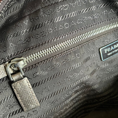 Vintage Prada Metallic Saffiano Bauletto Bag crafted from metallic gold saffiano leather embodies vintage elegance and modern luxury. Detailed with gold-tone hardware, dual handles, and original accessories, it’s a testament to Prada’s enduring craftsmanship. A collector’s piece made to shine on any occasion.