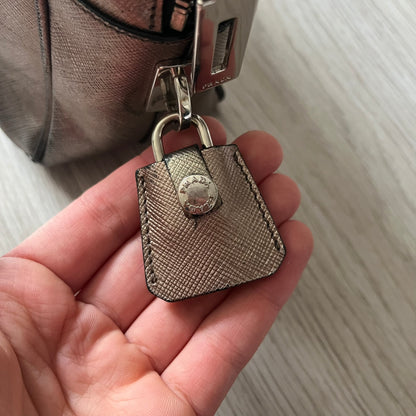 Vintage Prada Metallic Saffiano Bauletto Bag crafted from metallic gold saffiano leather embodies vintage elegance and modern luxury. Detailed with gold-tone hardware, dual handles, and original accessories, it’s a testament to Prada’s enduring craftsmanship. A collector’s piece made to shine on any occasion.