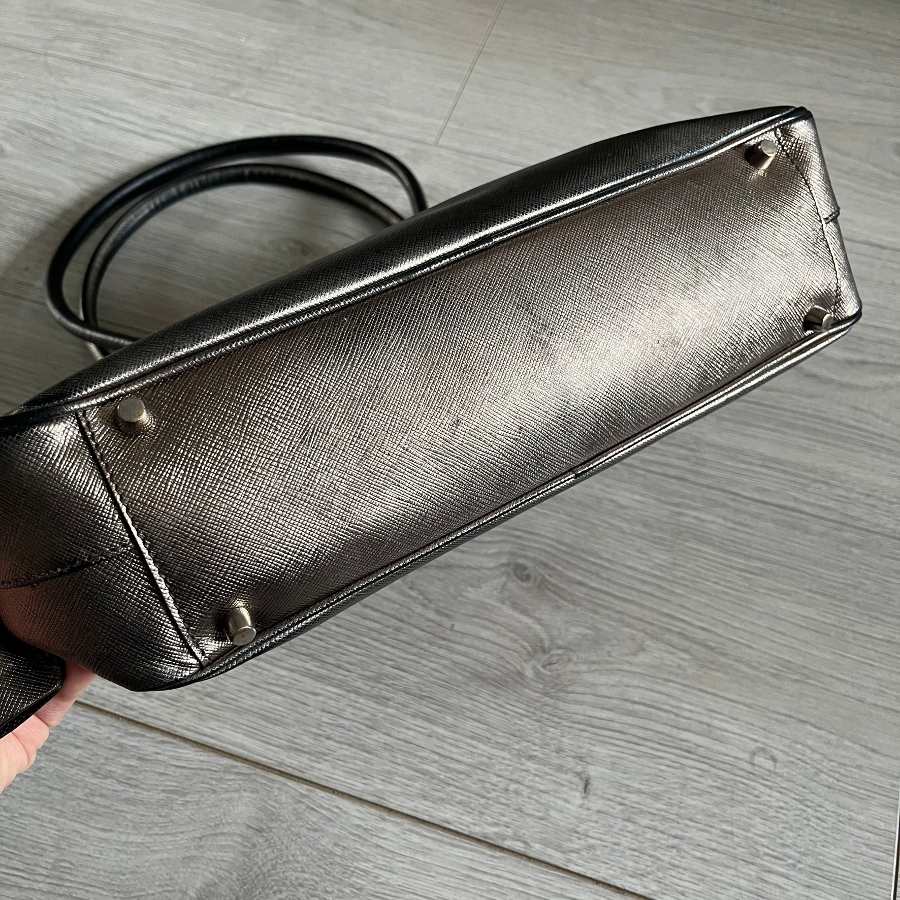 Vintage Prada Metallic Saffiano Bauletto Bag crafted from metallic gold saffiano leather embodies vintage elegance and modern luxury. Detailed with gold-tone hardware, dual handles, and original accessories, it’s a testament to Prada’s enduring craftsmanship. A collector’s piece made to shine on any occasion.