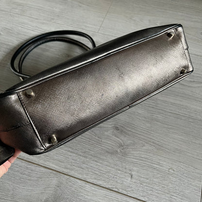 Vintage Prada Metallic Saffiano Bauletto Bag crafted from metallic gold saffiano leather embodies vintage elegance and modern luxury. Detailed with gold-tone hardware, dual handles, and original accessories, it’s a testament to Prada’s enduring craftsmanship. A collector’s piece made to shine on any occasion.