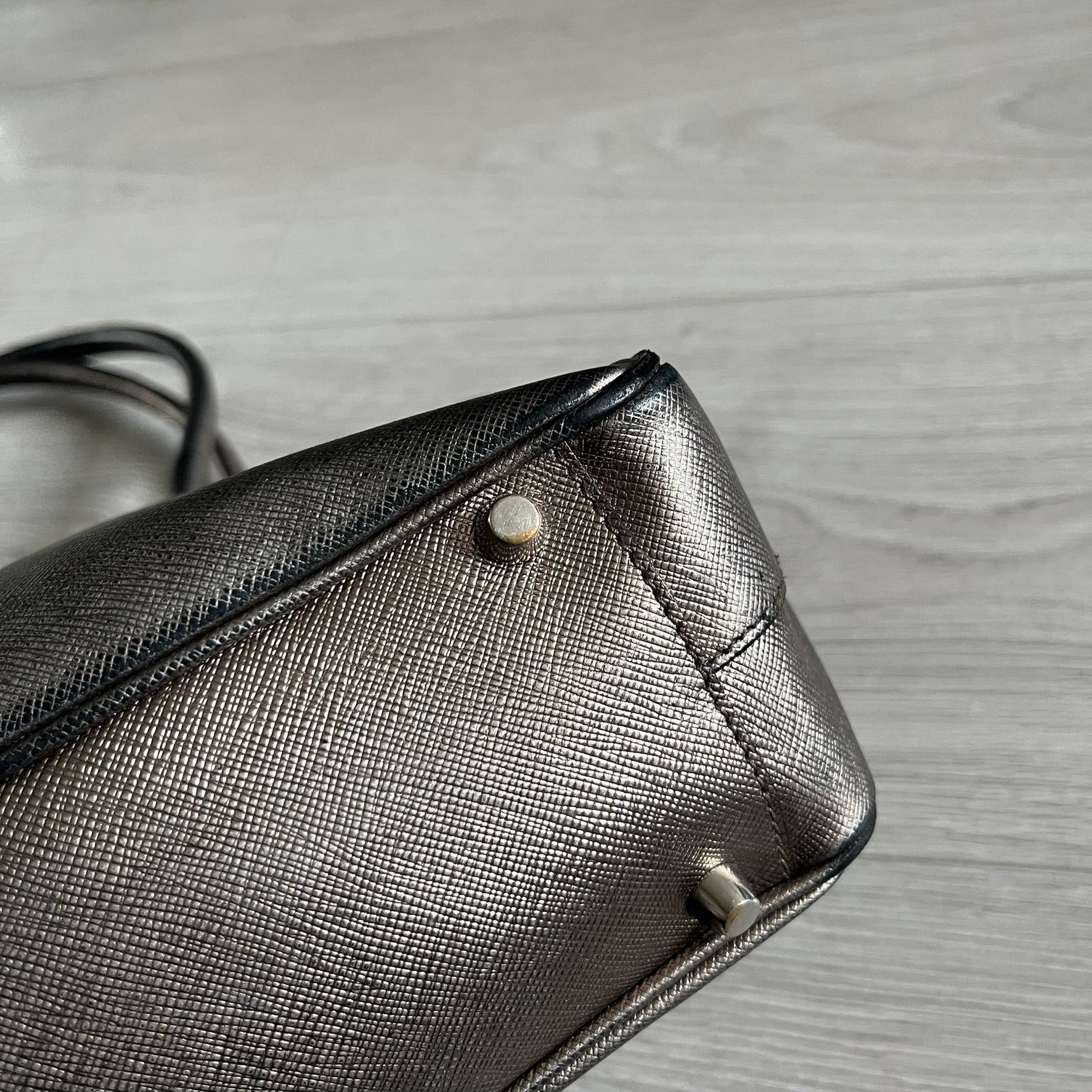 Vintage Prada Metallic Saffiano Bauletto Bag crafted from metallic gold saffiano leather embodies vintage elegance and modern luxury. Detailed with gold-tone hardware, dual handles, and original accessories, it’s a testament to Prada’s enduring craftsmanship. A collector’s piece made to shine on any occasion.