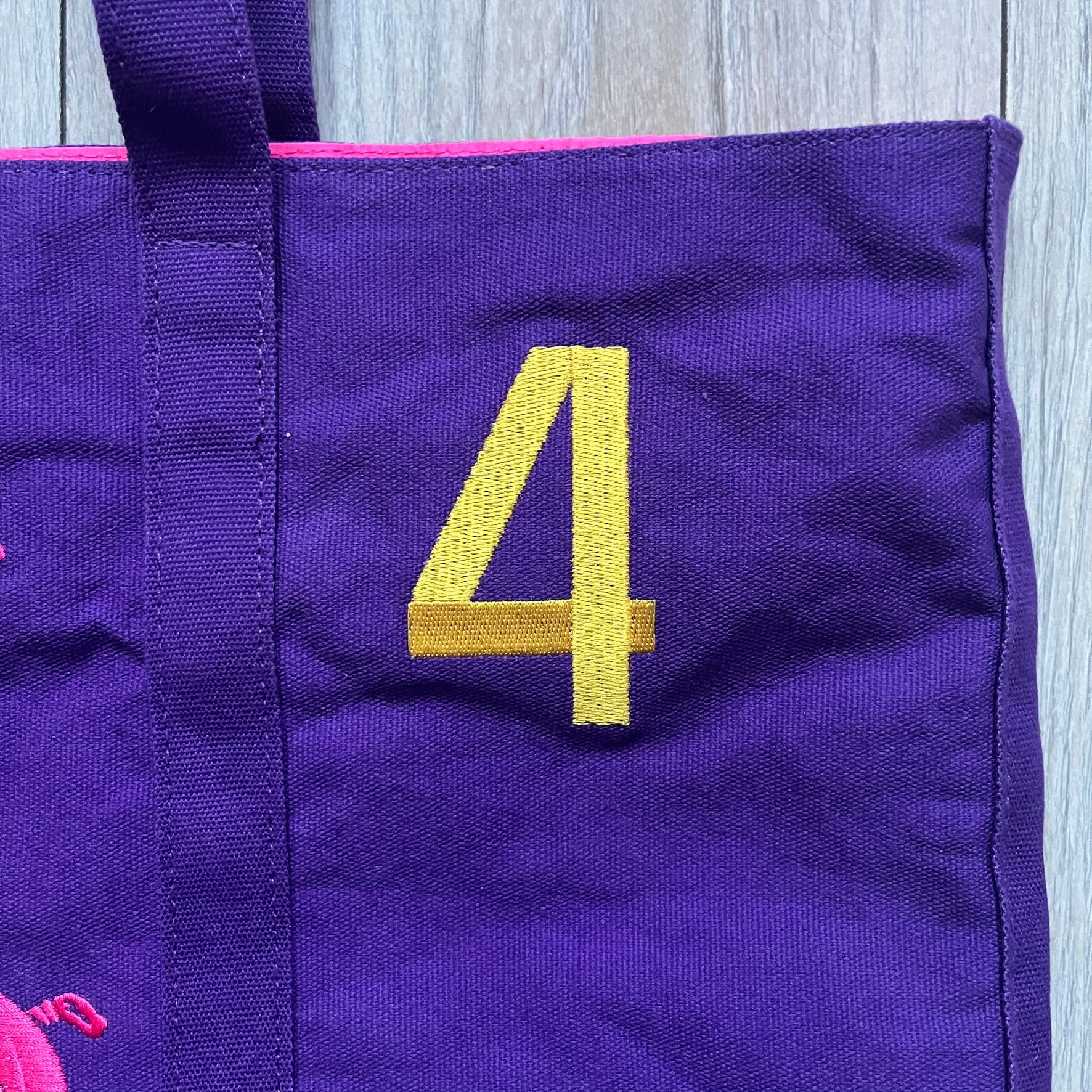 Ralph Lauren Purple &amp; Pink 4 thick tote bag with a large pink embroidered RL horse logo on the front. Yellow number "4" on the upper right. Interior is pink, made from a softer, smooth material. High-quality embroidery and sturdy exterior construction.