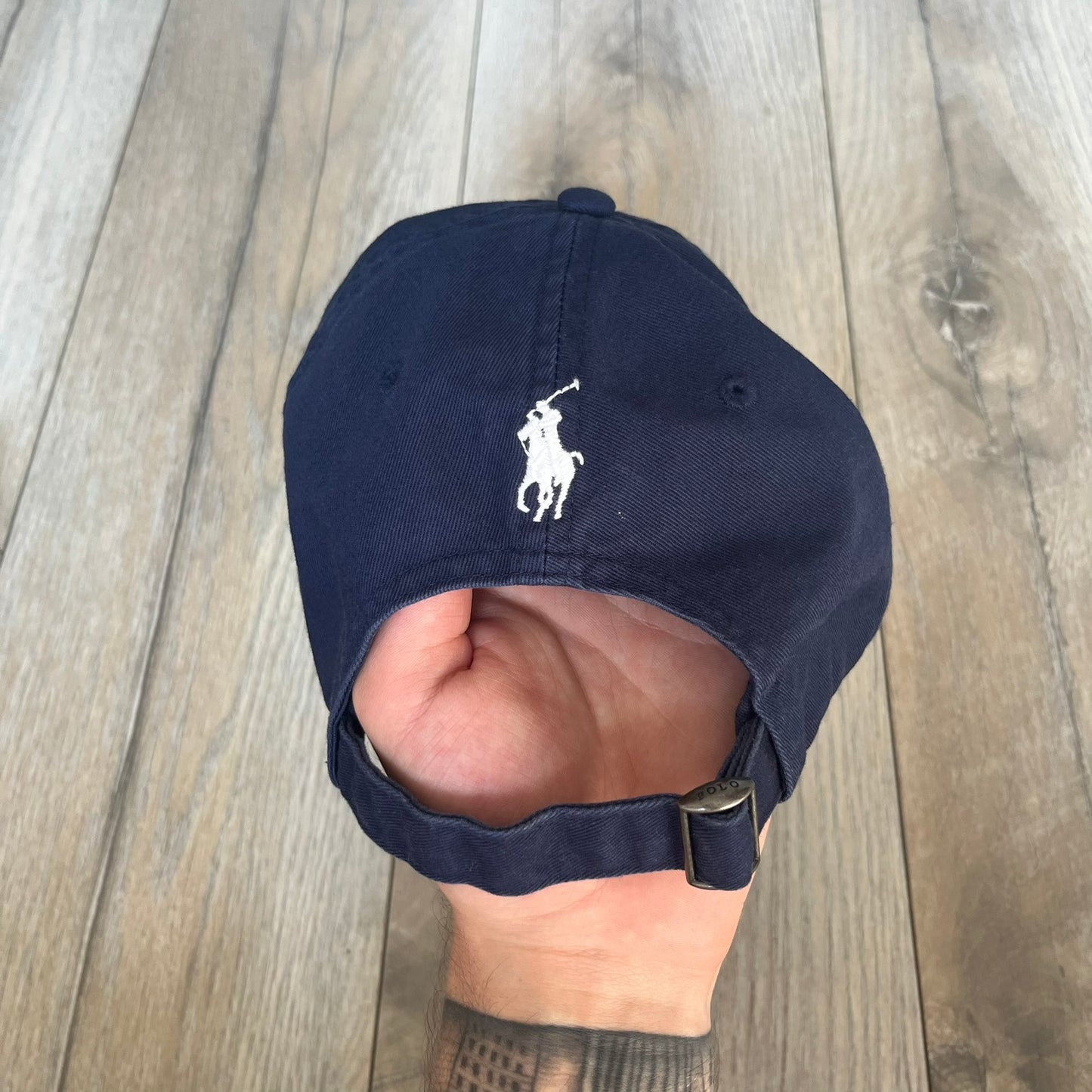 Ralph Lauren x Fortnite Navy Logo Baseball Cap is a navy cotton cap featuring bold embroidered branding on the front, including red Polo Ralph Lauren text and a Fortnite logo patch combined with a USA Ralph Lauren crest. The back includes a white embroidered Ralph Lauren logo and an adjustable strap for a custom fit.