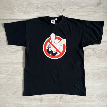 Raving Rabbids - known as “Lapins Crétins” in France - 2010 Tee in black, features a white Rabbid head inside a red circle with a slash, similar to a forbidden symbol. Officially licensed by Ubisoft, it comes with branding tags for collector and fan authenticity.&nbsp;