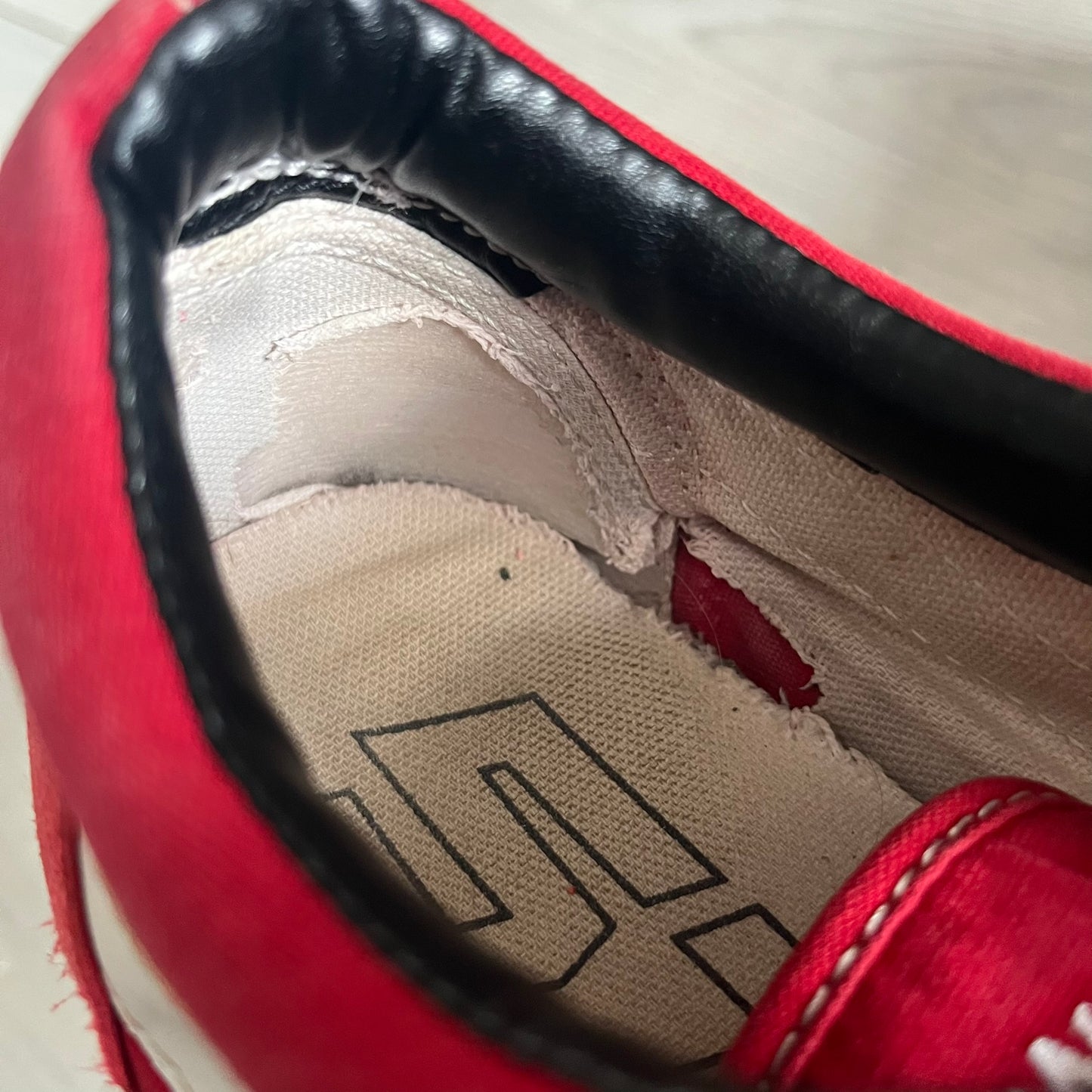Revenge x Storm Red Strap Sneakers designed by Ian Connor. Featuring a red upper with white leather lightning bolts replacing the traditional Vans stripe. Finished with Velcro strap closures, white midsoles, black outsoles, and the signature “Revenge x Storm” branding in red on the sole.
