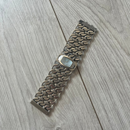 Roberto Cavalli 2000s Double Chain Steel Analog Watch is a stainless steel watch with a double-chain bracelet and a clip-style clasp. The dial has a pearlescent finish that changes appearance depending on the light. It features two asymmetrical silver hands and a stainless steel case. The watch is rated for 3 ATM water resistance.
