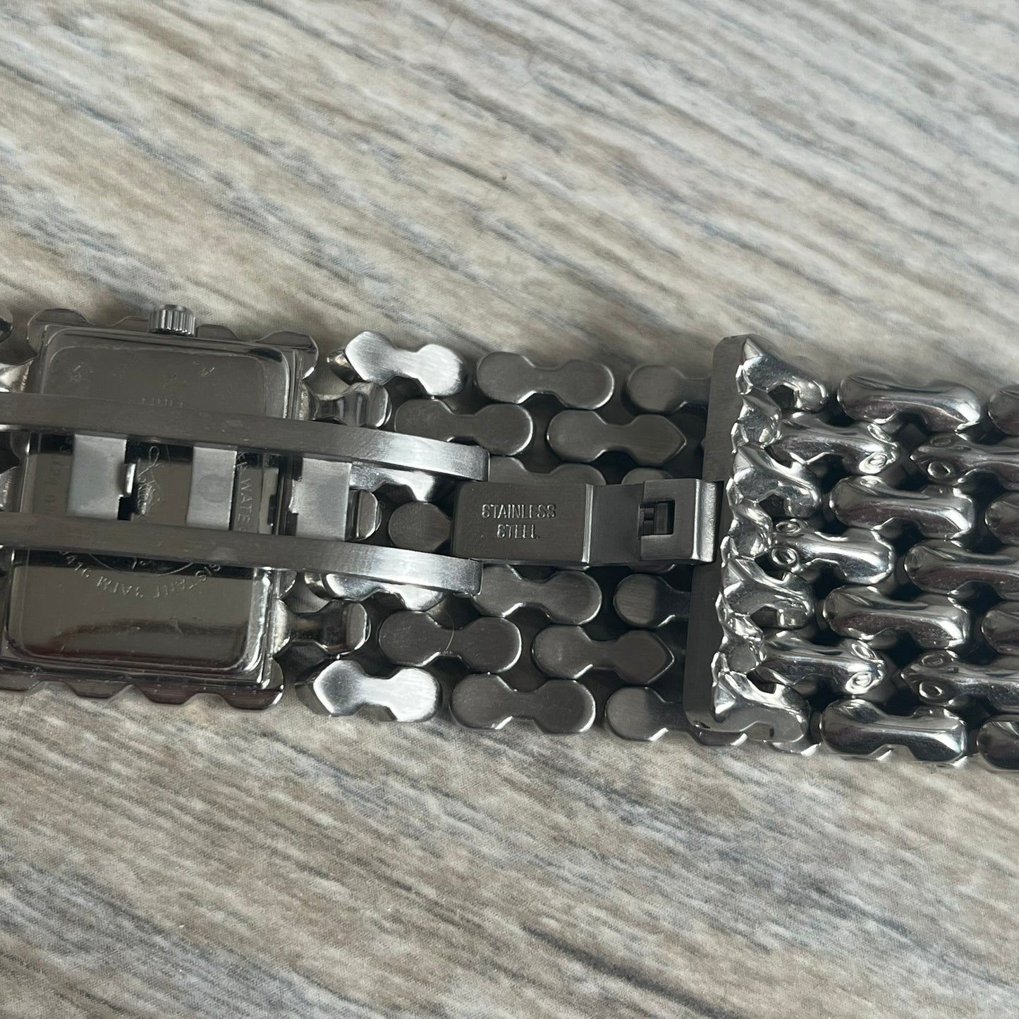 Roberto Cavalli Bones Steel Oryza Analog Watch R7253124015 is a stainless steel analog watch featuring a silver-tone case and integrated bracelet designed with bone-shaped link elements. The dial is aligned with the width of the bracelet, creating a continuous one-piece construction, and includes Cavalli-designed hands. This model uses a quartz movement.