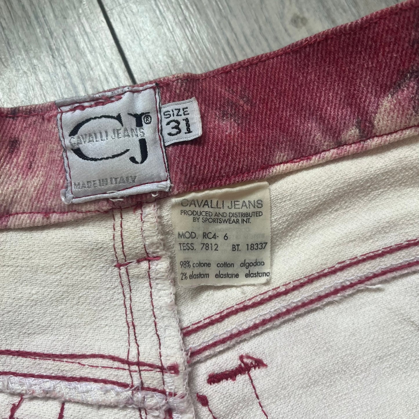 Roberto Cavalli Pink Floral 2000’s Jeans are made in Italy from 98% cotton and 2% elastane. The jeans feature an all-over floral print in multiple shades of pink, ranging from light to dark, with a hand-painted effect across the fabric. Details include branded buttons, a leather logo tab at the back, and classic five-pocket construction with two front and two back pockets.