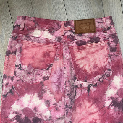 Roberto Cavalli Pink Floral 2000’s Jeans are made in Italy from 98% cotton and 2% elastane. The jeans feature an all-over floral print in multiple shades of pink, ranging from light to dark, with a hand-painted effect across the fabric. Details include branded buttons, a leather logo tab at the back, and classic five-pocket construction with two front and two back pockets.