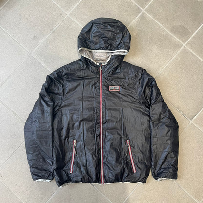 Roberto Cavalli Sport 2010's Black Lightweight Jacket is a lightweight hooded jacket in black with a gray interior, featuring two front pockets and star logo zipper pulls. A rubber Roberto Cavalli Sport logo patch sits on the chest, with a smaller matching patch on the upper back.