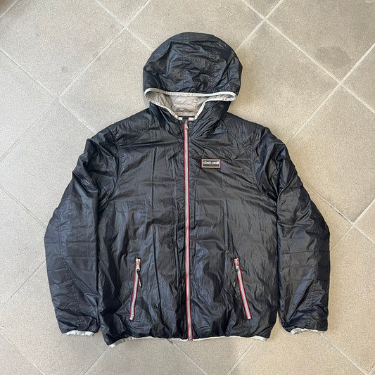 Roberto Cavalli Sport 2010's Black Lightweight Jacket is a lightweight hooded jacket in black with a gray interior, featuring two front pockets and star logo zipper pulls. A rubber Roberto Cavalli Sport logo patch sits on the chest, with a smaller matching patch on the upper back.