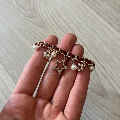 Set of four Rocawear bracelets, each with distinct design elements. Highlights include a “Girl Power” cube bracelet, a burgundy string with gold chain and pearl/zirconia charms, and two simple rose gold bands. Comes presented in a holographic silver box, ideal for collectors or as a stylish accessory set.