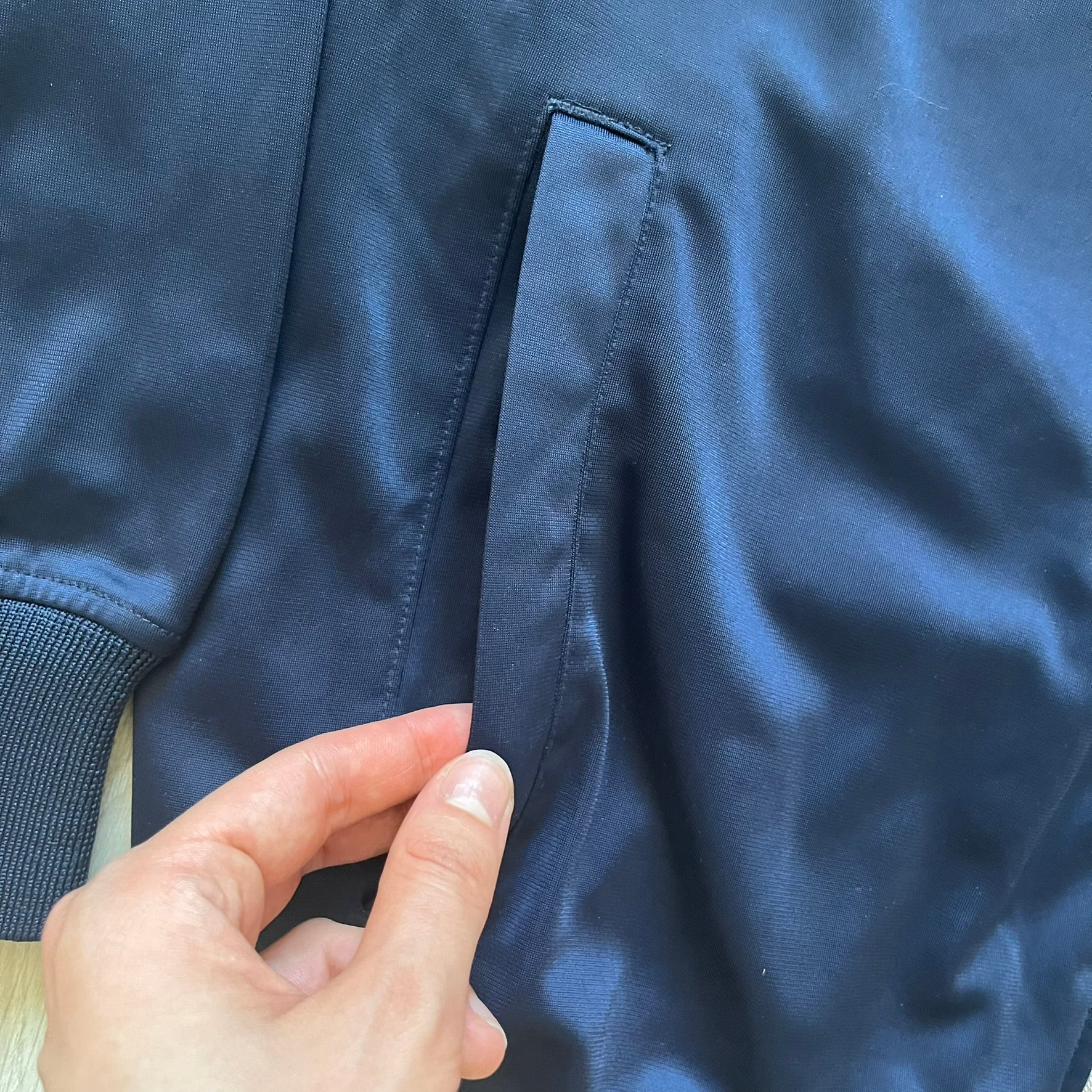 Rocawear Dark Navy Vintage Track Jacket, featuring a small embroidered logo on the chest and a large white logo across the back, finished with a silver emblem near the wrist and a detailed silver zipper.