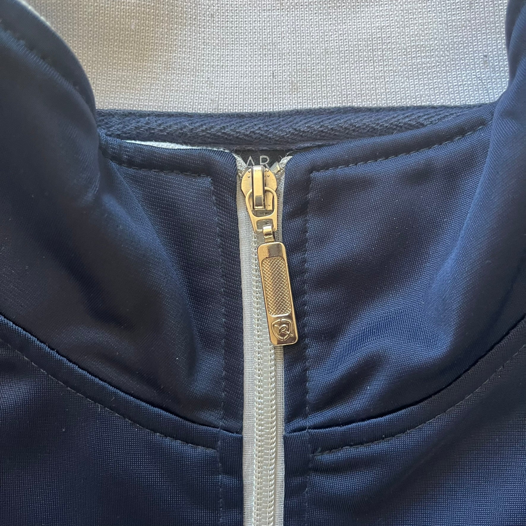 Rocawear Dark Navy Vintage Track Jacket, featuring a small embroidered logo on the chest and a large white logo across the back, finished with a silver emblem near the wrist and a detailed silver zipper.