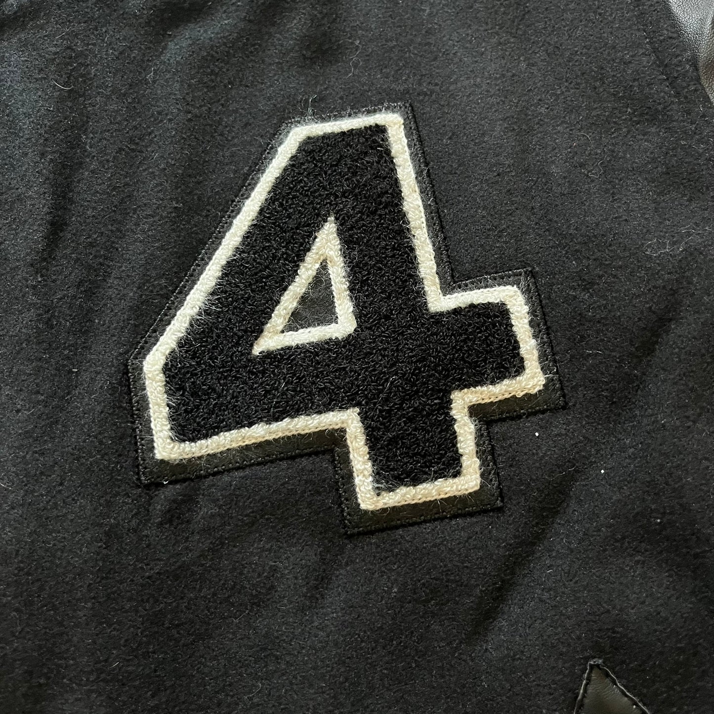 Rocawear black bomber jacket detailed with multiple statement patches, including “R” and “W” on the shoulders, a Rocawear logo with a “4” on the chest, and a large text logo across the back. Crafted with great detailing, it reflects the brand’s early 2000s streetwear identity.