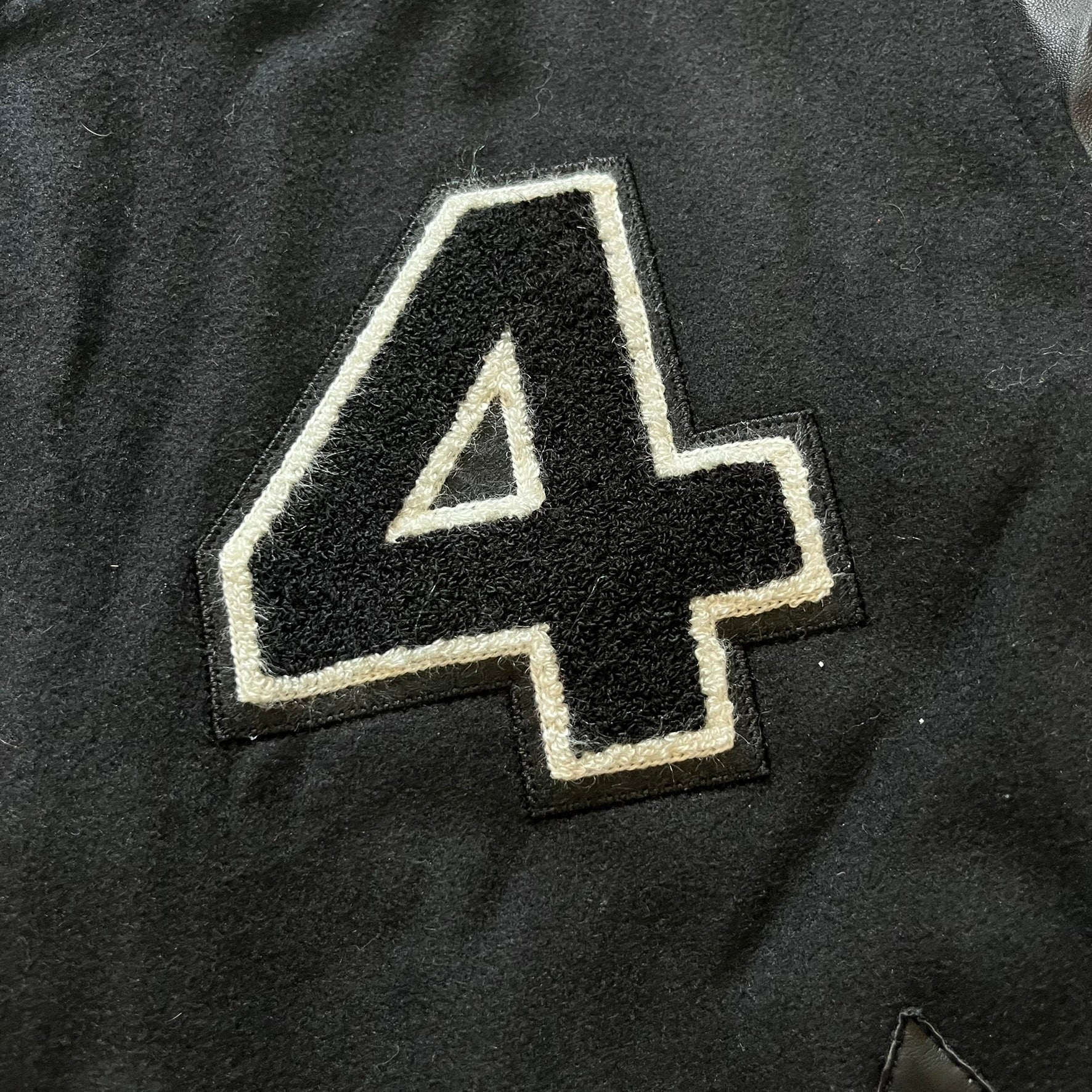 Rocawear black bomber jacket detailed with multiple statement patches, including “R” and “W” on the shoulders, a Rocawear logo with a “4” on the chest, and a large text logo across the back. Crafted with great detailing, it reflects the brand’s early 2000s streetwear identity.