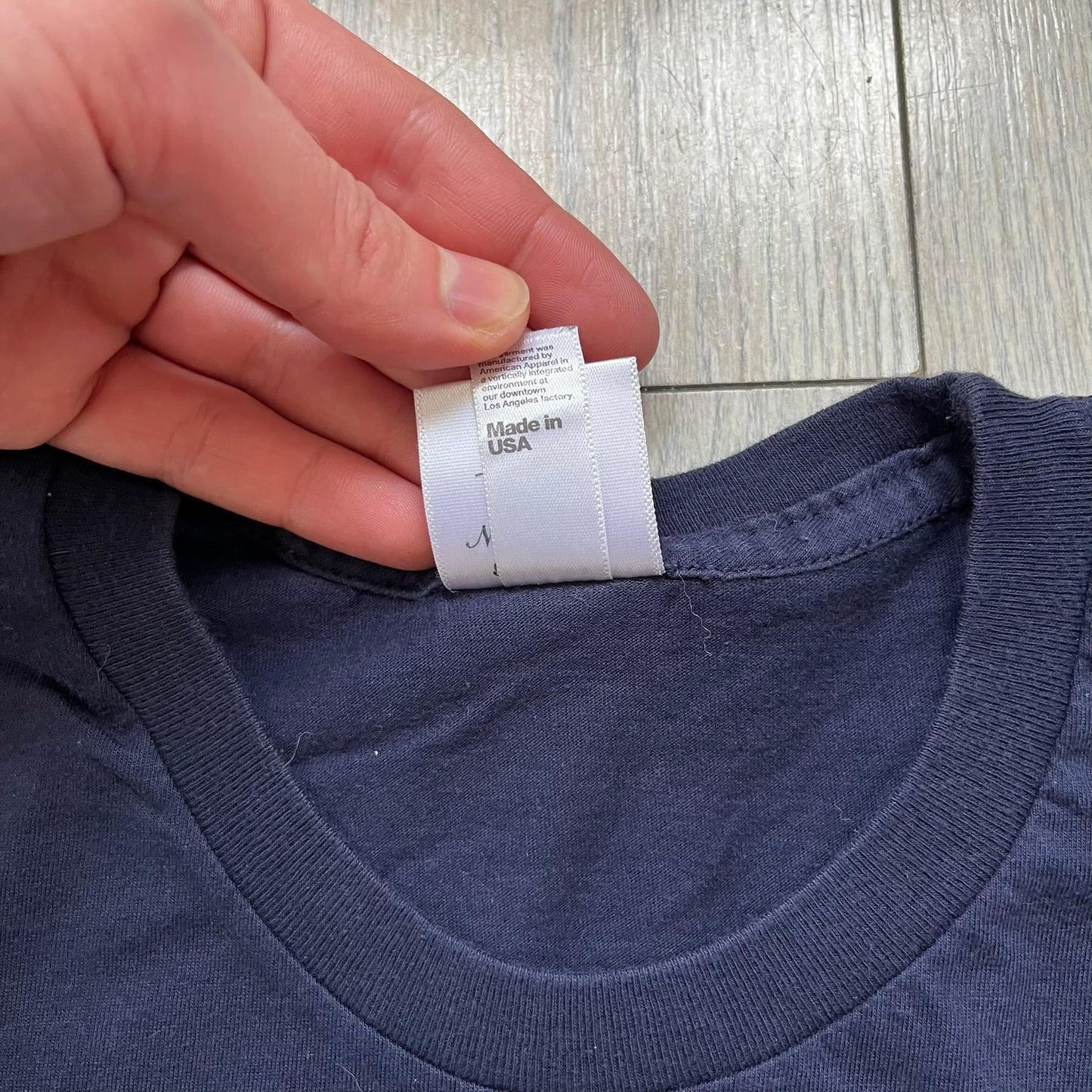 Rockstar Games 'Canis Canem Edit (Bully)' Navy Tee is a dark navy T-shirt made in the USA featuring a yellow "Canis Canem Edit" text on the chest, referencing the original Bully game title. The back displays a large yellow Bullworth Academy logo, while a small yellow Rockstar logo is printed on the sleeve. The shirt includes an official Rockstar Games neck tag.