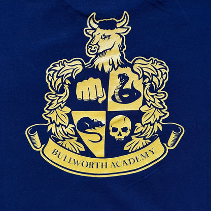 Rockstar Games 'Canis Canem Edit (Bully)' Navy Tee is a dark navy T-shirt made in the USA featuring a yellow "Canis Canem Edit" text on the chest, referencing the original Bully game title. The back displays a large yellow Bullworth Academy logo, while a small yellow Rockstar logo is printed on the sleeve. The shirt includes an official Rockstar Games neck tag.