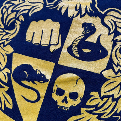 Rockstar Games 'Canis Canem Edit (Bully)' Navy Tee is a dark navy T-shirt made in the USA featuring a yellow "Canis Canem Edit" text on the chest, referencing the original Bully game title. The back displays a large yellow Bullworth Academy logo, while a small yellow Rockstar logo is printed on the sleeve. The shirt includes an official Rockstar Games neck tag.