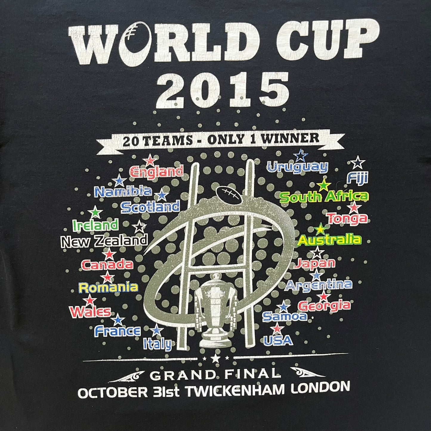 2015 Rugby World Cup tee featuring a front print with a world map, all participating countries, and “2015 World Cup” text. The back displays the date and location of the grand final along with the text “20 teams – only 1 winner.” An official commemorative piece from the 2015 tournament.